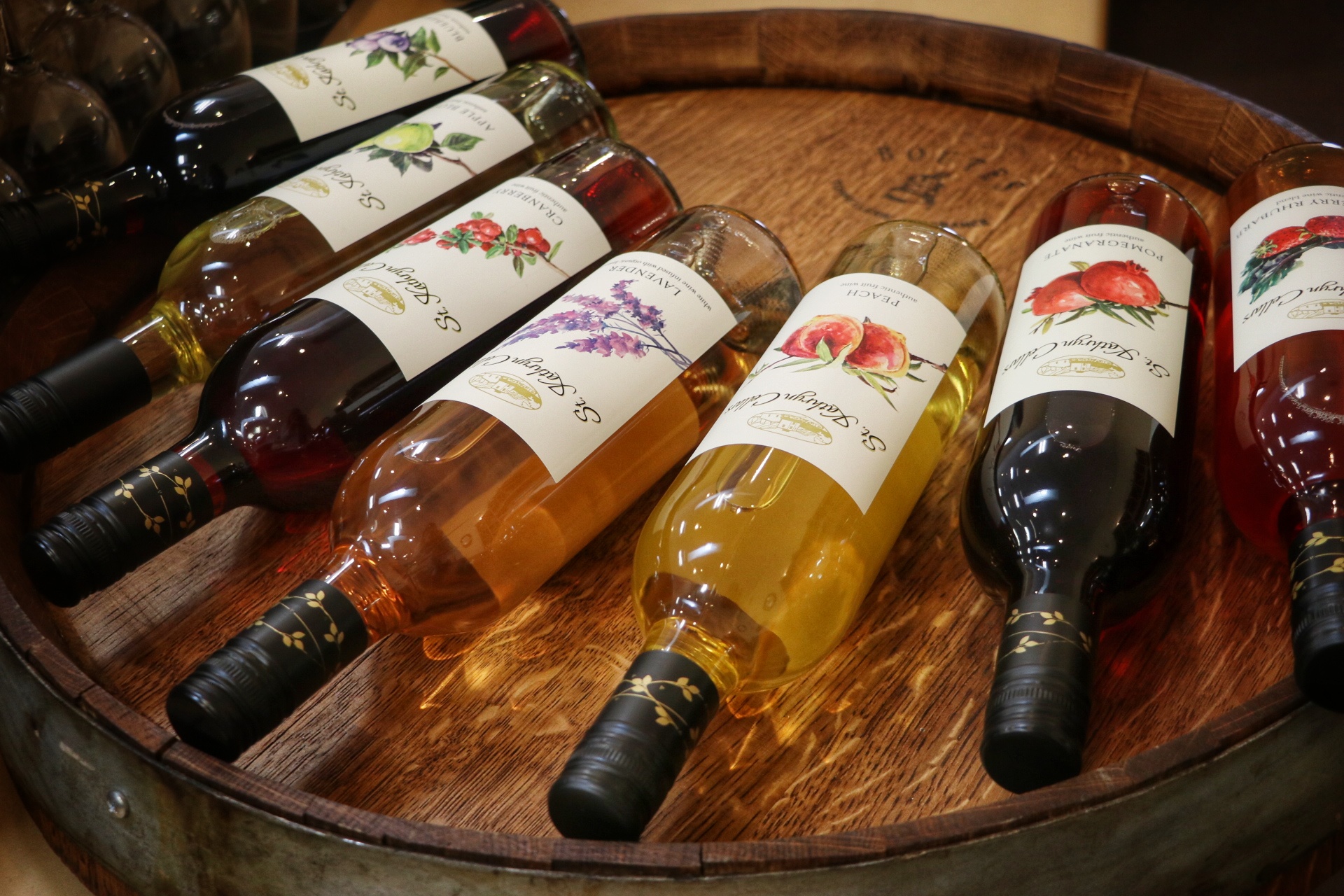 Bottles of wine lying on top of a barrel